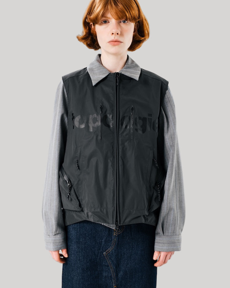 Person wearing a black and gray jacket with a white background