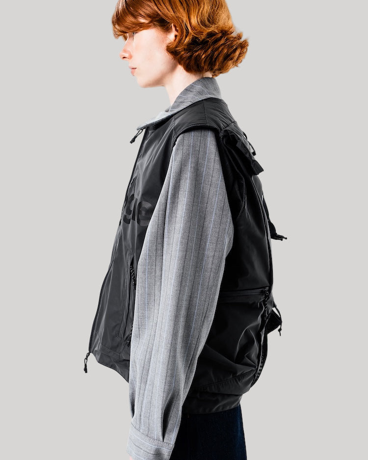 Person wearing a black jacket with a gray scarf on a white background